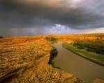 Approaching storm on the Milk River at Writing on Stone Provincial Park, Alberta, Canada by Chuck Haney / Danita Delimont