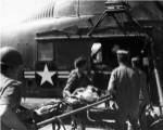 Army soldiers carrying an injured person in a helicopter