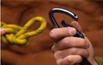 Close-up of human hands holding a carabiner and rope