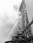 Fire engine with ladder up burning building