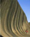 Person climbing Wave Rock, Western Australia, Australia