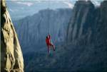 Rear view of a man rappelling down a rock