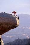 Side profile of a young man pulling a young woman onto a rock