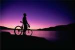 Silhouette of a man standing with his mountain bike, Lake Powell, Utah, USA