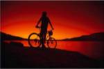 Silhouette of a man standing with his mountain bike, Lake Powell, Utah, USA