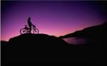 Silhouette of a man standing with his mountain bike, Lake Powell, Utah, USA