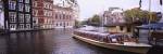 Tourboat in a channel, Amsterdam, Netherlands by Panoramic Images
