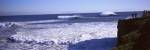 Tourist looking at waves in the sea, Santa Cruz, Santa Cruz County, California, USA by Panoramic Images