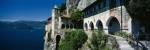 Walkway along a building at a lake, Santa Caterina del Sasso, Lake Maggiore, Piedmont, Italy by Panoramic Images