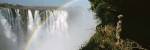 Woman looking at a rainbow over the Victoria Falls, Zimbabwe by Panoramic Images