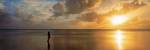 Woman standing on sandbar looking at sunset, Aitutaki, Cook Islands by Panoramic Images