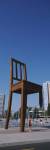 Woman standing under a sculpture of large broken chair, Geneva, Switzerland by Panoramic Images